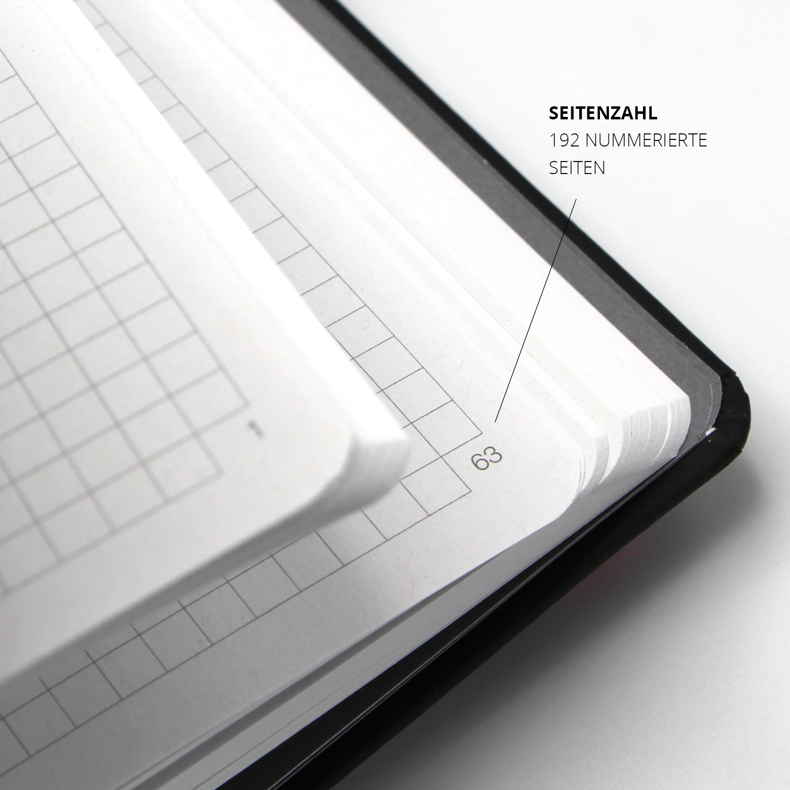 Detailansicht der Innenseiten des Lanybook® Nature Notizbuchs in Schwarz mit pinkem Lanyband. Die Seiten sind kariert und durchnummeriert – hier sichtbar ist die Seitenzahl 63 von insgesamt 192 Seiten auf FSC-zertifiziertem Recyclingpapier.