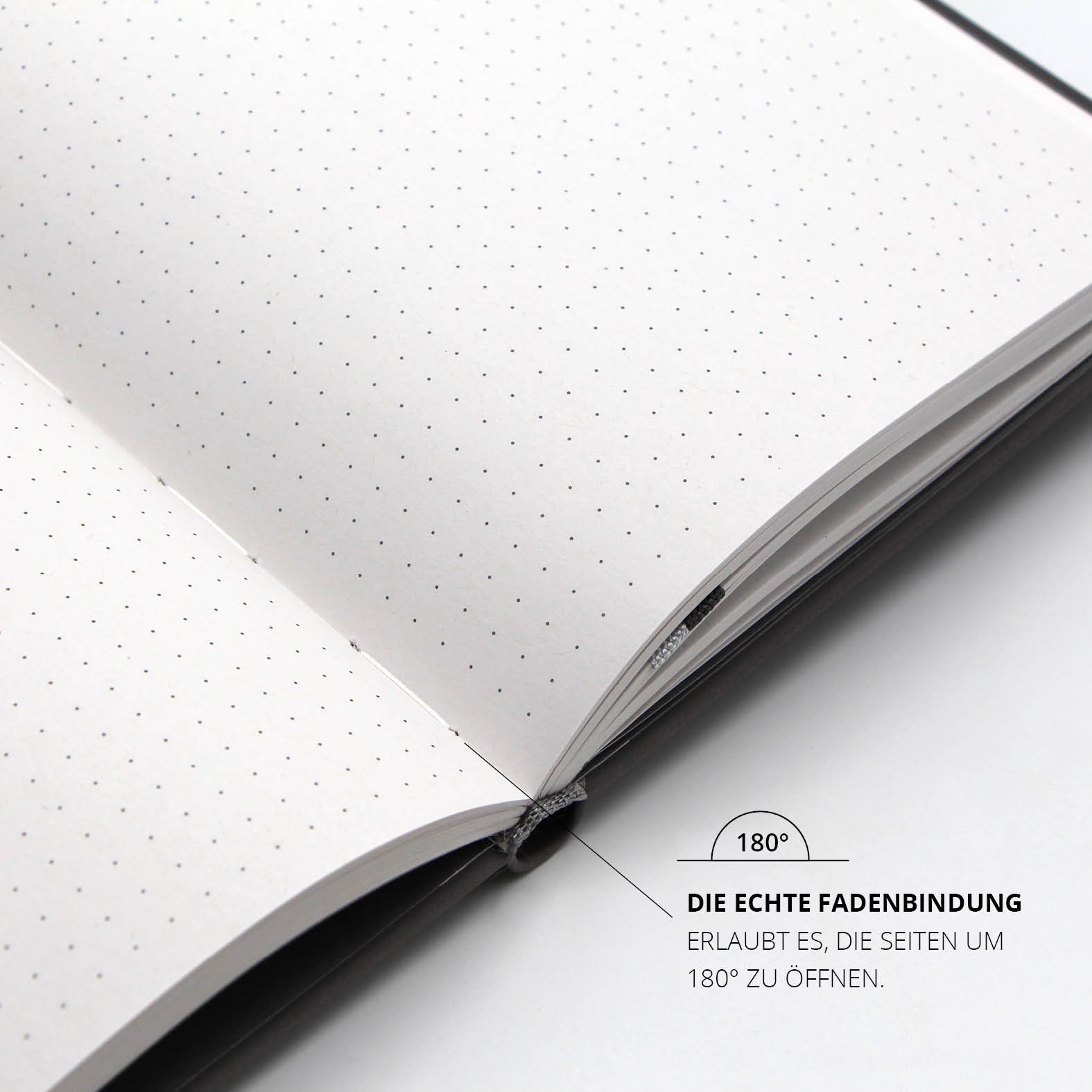 Geöffnetes Lanybook® Nature Notizbuch mit echter Fadenbindung, die ein flaches Aufschlagen um 180 Grad ermöglicht, sichtbar sind punktierte Innenseiten aus Recyclingpapier.