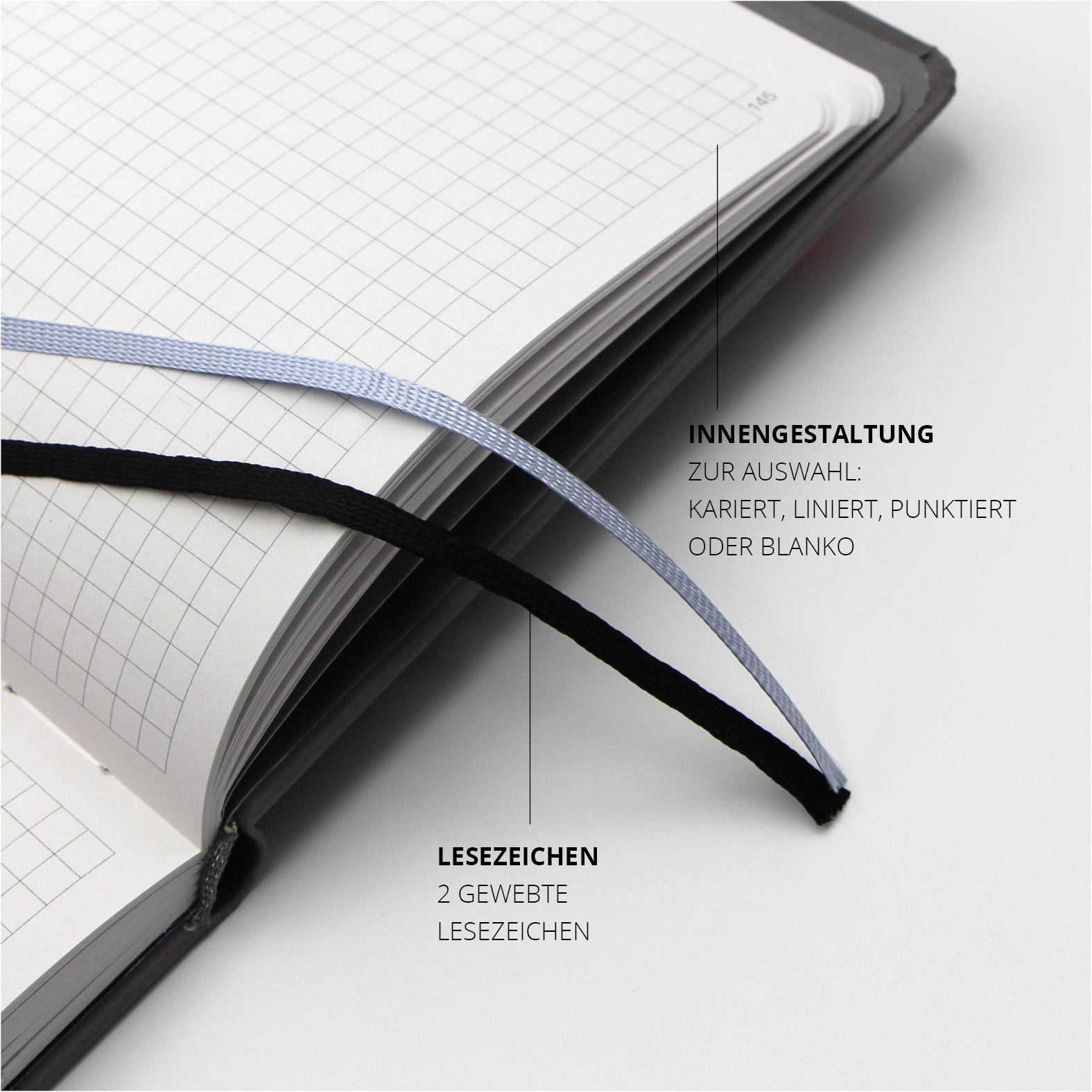 Zwei gewebte Lesezeichen in Schwarz und Weiß im Inneren des Lanybook® Nature, ergänzend zur karierten Innengestaltung.