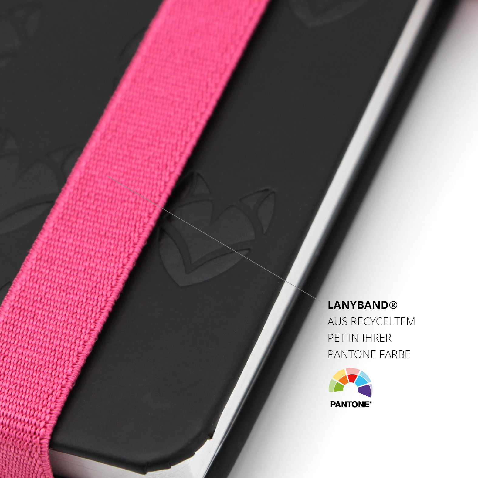 Detailaufnahme des pinken Lanyband® aus recyceltem PET in Pantonefarbe, über dem geprägten Cover mit LUNISA-Motiv.