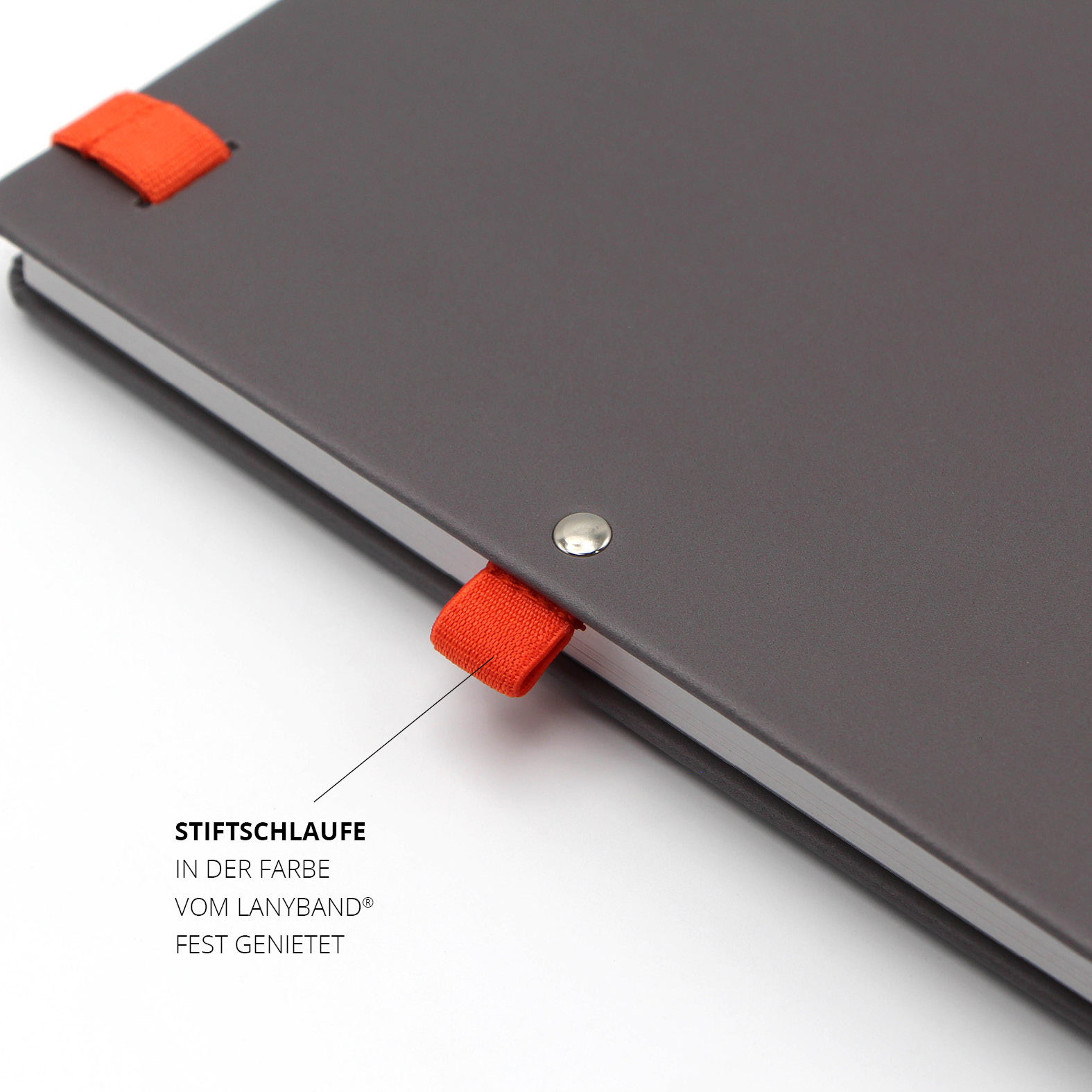 Nahaufnahme der fest vernieteten Stiftschlaufe in der Farbe des orangenen Lanybands®. Sie ergänzt das Design des nachhaltigen Lanybook® Nature mit veganem Apfelleder-Einband.