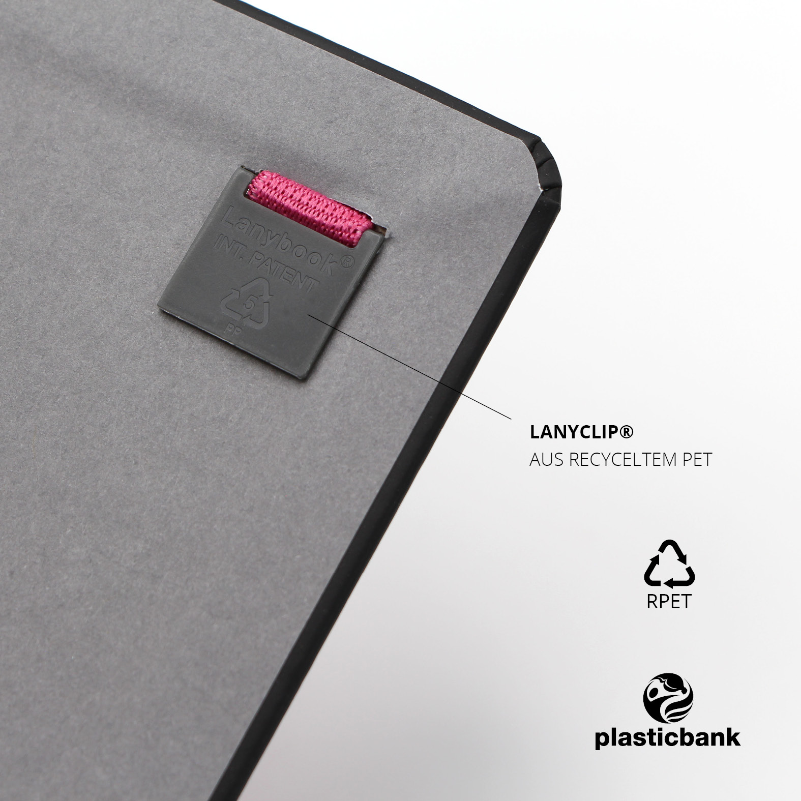 Lanybook® Rückseite mit schwarzem Lanyclip® aus recyceltem PET und eingeprägtem Recycling-Symbol. Verbindung zum pinken Lanyband sichtbar.