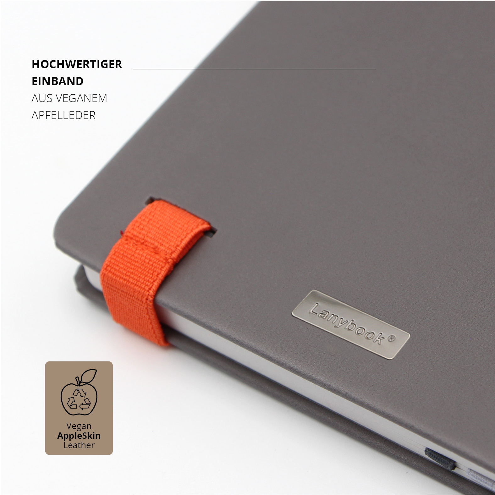 Detailaufnahme des grauen Covers des Lanybook® Nature mit orangem Lanyband und metallischem Lanybook®-Label. Hochwertiger Einband aus veganem Apfelleder.